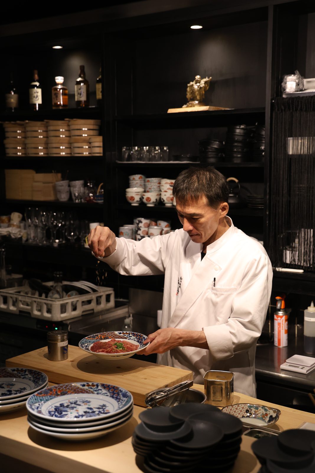 薬院の焼肉店「牛歩」、カウンターで仕上げをするシェフ