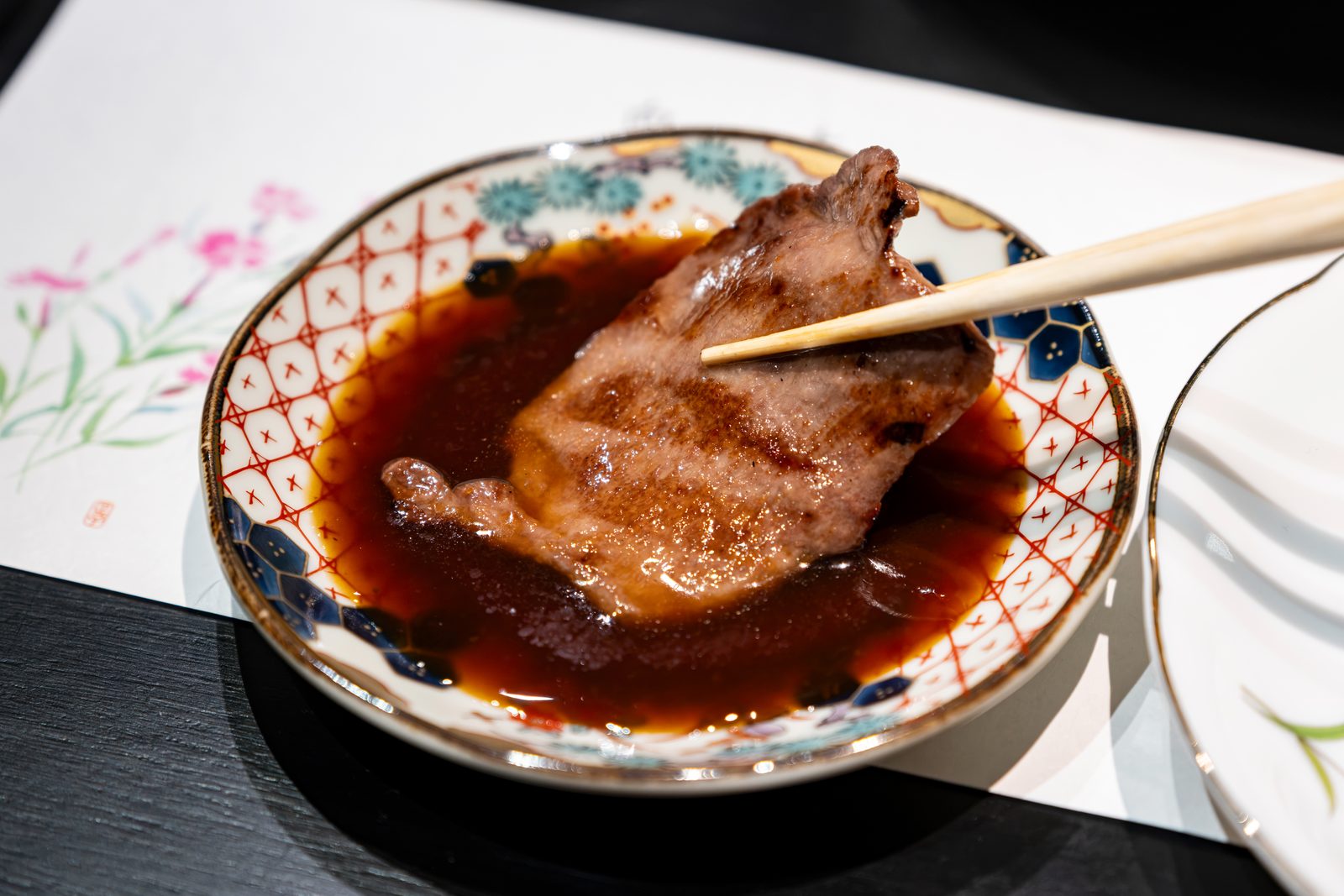 焼肉 牛歩の特製タレに肉を浸す手元